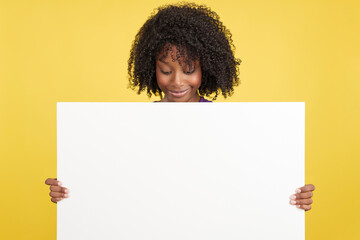 Woman with afro hair looking down to a blank board