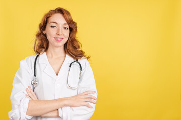 Redheaded female doctor smiling at the camera with arms crossed