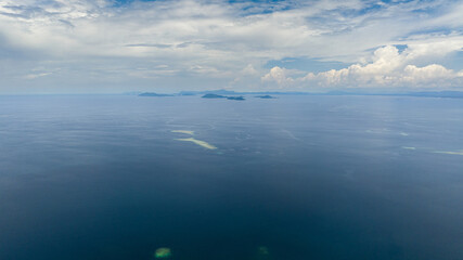 Blue ocean and blue sky with clouds. Seascape in the tropics. Flight over the sea. Borneo, Malaysia.