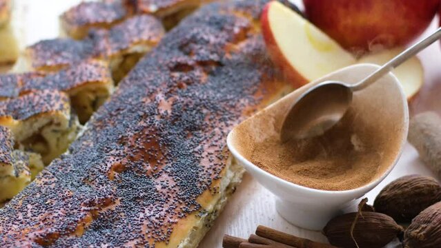 seasoning cinnamon in a small cup sprinkled with spoon look sprinkled with cinnamon pies in the background apple strudel poppy delicious stuffing food flavor for health natural