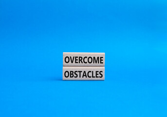 Overcome obstacles symbol. Concept words Overcome obstacles on wooden blocks. Beautiful blue background. Business and Overcome obstacles concept. Copy space.