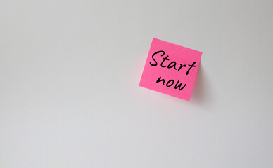 Start now symbol. Pink steaky note with words Start now. Beautiful white background. Business and Start now concept. Copy space.