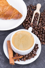Cup of coffee and fresh croissant with chocolate for breakfast