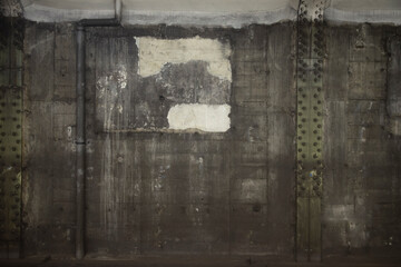 Obraz premium 背景 : パイプと鉄柱とボルトとポスター跡のある、コンクリート打ちっ放しの、地下鉄の壁 