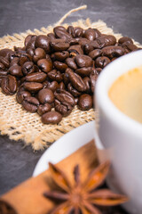 Coffee in cup and roasted dark coffee beans with anise and cinnamon