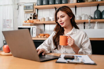 Young businesswoman drinking coffee and typing to searching busi