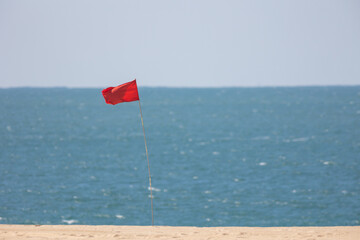 Red flag by the sea - warning sign