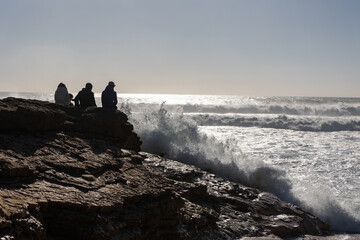 People sit on rocks and look at the sea