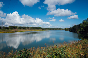 vue d'un lac en automne. Paysage d'un lac en France. étang de Longpendu. Ciel bleu et nuages se reflétant sur un lac. Ligne haute tension sur un lac