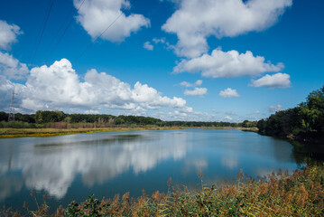 vue d'un lac en automne. Paysage d'un lac en France. étang de Longpendu. Ciel bleu et nuages se reflétant sur un lac. Ligne haute tension sur un lac