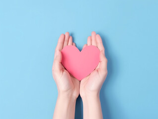 Obraz premium Women's hands holds a pink paper heart with copy space for text, valentines postcard, greeting card mockup, valentines day and mother day background