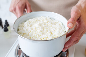 Woman making decorative aroma candles from soy wax