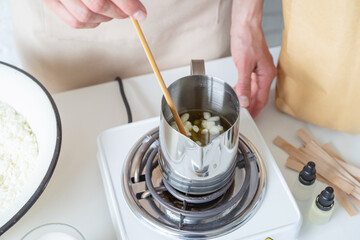 Woman making decorative aroma candles at table