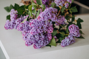 A bouquet of fresh lilacs on the table with a daylight.
