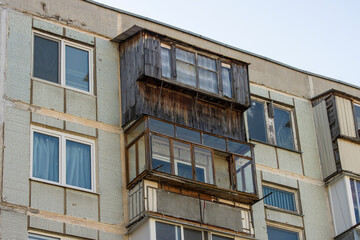 Close-up of an old dilapidated balcony lined with wood in an old soviet apartment building
