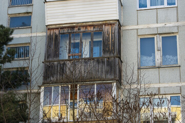 Fototapeta na wymiar Close-up of an old dilapidated balcony lined with wood in an old soviet apartment building