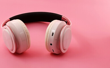 White headphones on a pink background. Space for text