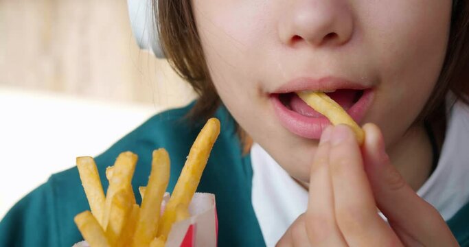 Teenage Girl Consuming Fast Food French Fries. Youth addiction to junk food.
