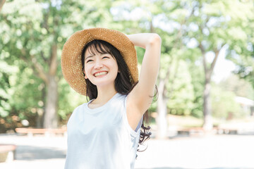 帽子を被って紫外線対策するアジア人女性（日焼け止め・UVケア）
