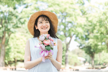 花束・ブーケを持つ帽子を被った女性
