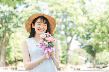 花束・ブーケを持つ帽子を被った女性
