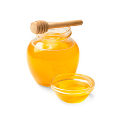 Honey in a jar with a wooden dipper on a white isolated background.