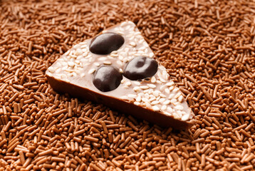A piece of chocolate pizza lies in a chocolate crumb close-up.