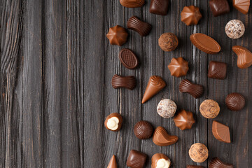 Fototapeta na wymiar Assorted chocolates on dark wooden background top view