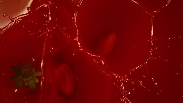 strawberries dropping into strawberry juice or jam mixture - top shot