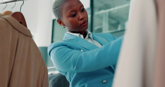 Fashion, retail and black woman checking clothes and product in small business in Africa. Clothing store, startup and African businesswoman, owner of designer boutique looking at jackets for quality.