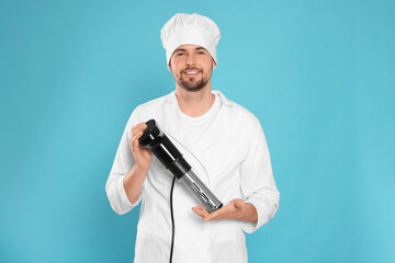 Smiling chef holding sous vide cooker on light blue background