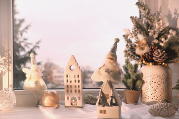 Many beautiful Christmas decorations and fir branches on window sill indoors