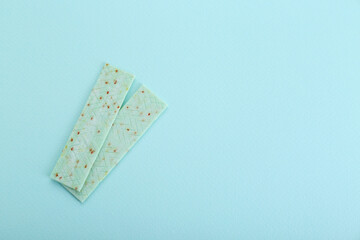 Sticks of tasty chewing gum on light blue background, flat lay. Space for text