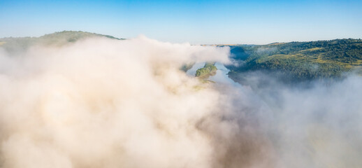 In the morning, a thick white fog hovers over the river. Dniester canyon national park, Ukraine, Europe.