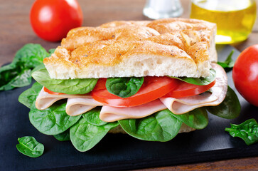 Focaccia Sandwich with Ham, Tomatoes, and Spinach, Sandwich with Italian Flat Bread on Wooden Background
