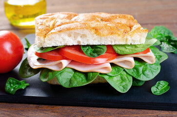 Focaccia Sandwich with Ham, Tomatoes, and Spinach, Sandwich with Italian Flat Bread on Wooden Background