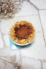 Tiramisu cake in a glass cup on white marble background
