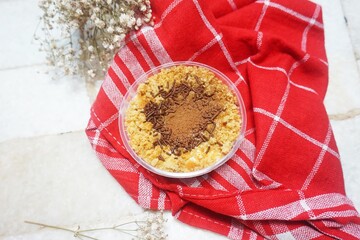 Tiramisu cake in a glass cup on white marble background