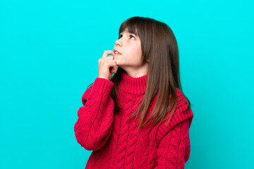 Little caucasian girl isolated on blue background is a little bit nervous