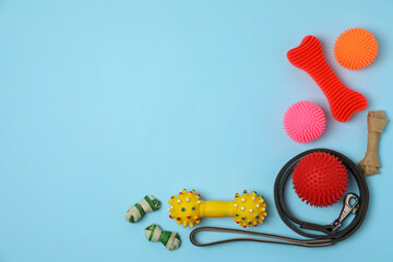 Flat lay composition with dog leash and toys on light blue background, space for text