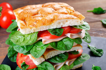 Focaccia Sandwich with Ham, Tomatoes, and Spinach, Sandwich with Italian Flat Bread on Wooden Background