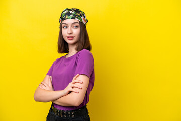 Young Ukrainian woman isolated on yellow background looking to the side and smiling