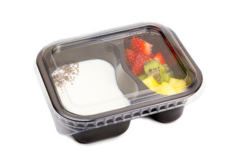 Portion of yogurt dessert with strawberry and kiwi and pineapple in a plastic bowl with a lid.