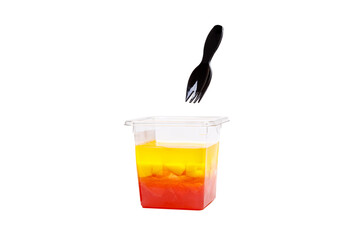 Grapefruit, mango and raspberry jelly in a plastic cup on a white background.