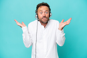 Telemarketer caucasian man working with a headset isolated on blue background having doubts while...
