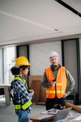 Architect caucasian man working with colleagues mixed race in the construction site. Architecture engineering on big project. Building in construction interior.