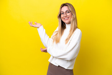 Young Uruguayan woman isolated on yellow background extending hands to the side for inviting to come