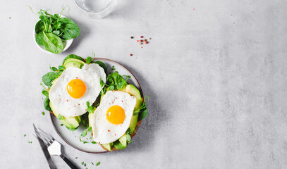 Avocado Sandwich with Fried Egg, Spinach and Green Sprouts, Healthy Breakfast or Snack on Bright Background