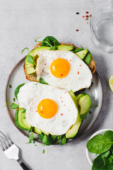 Avocado Sandwich with Fried Egg, Spinach and Green Sprouts, Healthy Breakfast or Snack on Bright Background