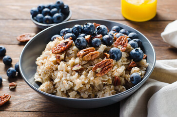 Oatmeal Bowl, Oat Porridge with Blueberry and Pecans in a Bowl on Rustic Background, Healthy Snack or Breakfast